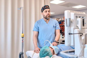 Médico realizando un bloqueo nervioso guiado por ecografía para cirugía de hombro.